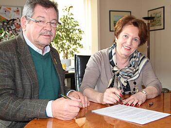 Bürgermeisterin Brigitte Meyerdierks und Hans Rohrmüller, Vorsitzender des Forums, unterzeichnen am 6. März 2015 den Vertrag, der die Organisation des Stadtfestes Bad Brückenau regelt. Foto: Ulrike Müller