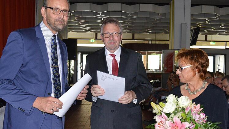 Der Ministerialbeauftragte Karl-Heinz Lamprecht überreicht Andreas Elsässer die Dankesurkunde, rechts Ehegattin Birgit Elsässer.
