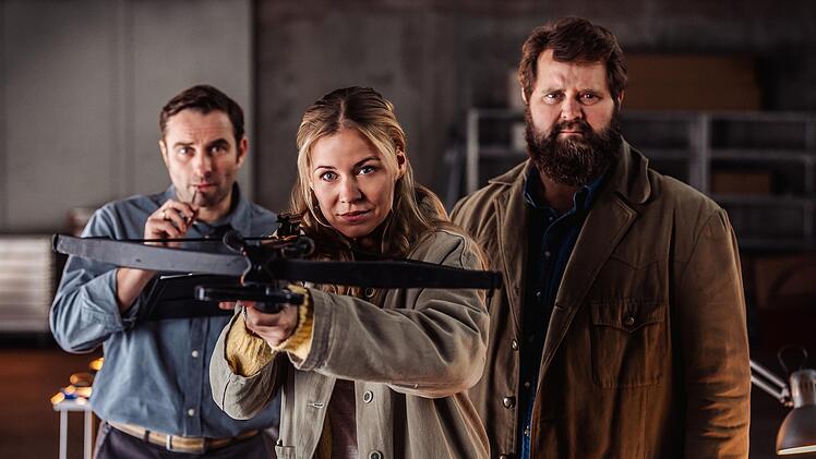 Praktisch, wenn man eine Schwester hat, die mit der Armbrust umgehen und bei den Ermittlungen helfen kann: Anne (Jessica Ginkel) zeigt ihrem Mann, Kriminaltechniker Sebastian Loncar (Jonas Laux, links), und ihrem Bruder Konrad Behringer (Antoine Monot), wie's geht.