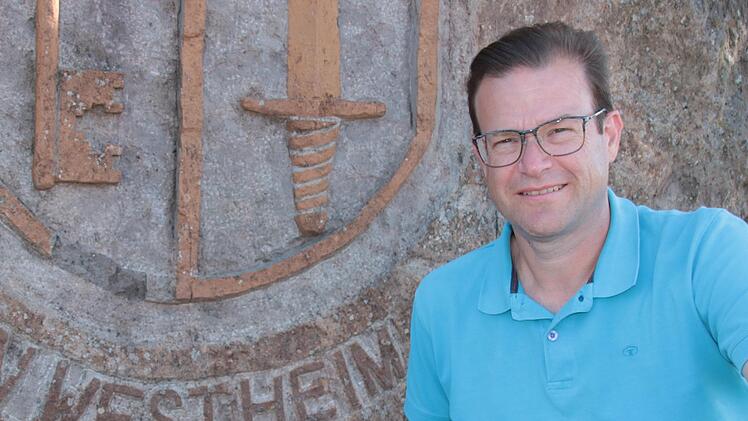 Norbert Schaub (SPD) ist neuer Ortsbeauftragter für Westheim, das Foto zeigt ihn vor dem Stein am Ortseingang.
