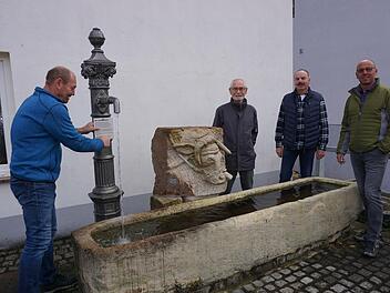 Rainer Rüttiger befestigte die Informationstafel am Eckenbrunnen. Mit im Bild Künstler Gerwin Kellermann, Albrecht Kimmel und Bürgermeister Gerd Kleinhenz