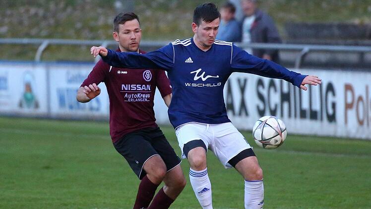 Frohnlachs Kevin Hartmann (blau) wird von Andre Singer von der SpVgg Erlangen bei der Ballannahme gestört.