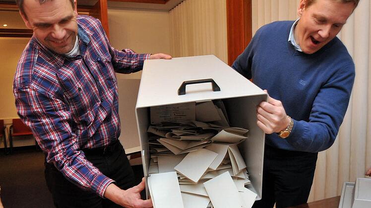 Helfer leeren eine Wahlurne. Foto: dpa