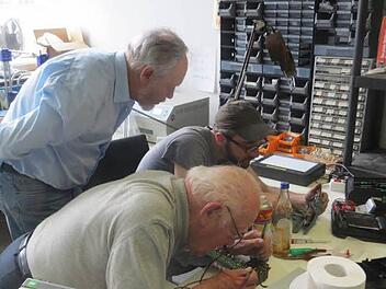 A bissl was geht immer: Nach diesem Motto kommt der 85-jährige Anton Ehrig (im Vordergrund) regelmäßig ins Reparatur-Café und bastelt gemeinsam mit Chris Herrmann (mit Mütze) an allem, woran man herumschrauben kann. Foto: Jürgen Weigert