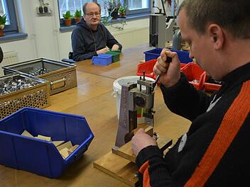 Im "Haus Jonathan" in Maria Bildhausen sind die Werkstätten. Hier werden unter anderem die Anzünder produziert. Unser Bild zeigt Matthias beim Spalten der kleinen Holztafeln. Im Hintergrund Bernd.  Fotos: Friedrich
