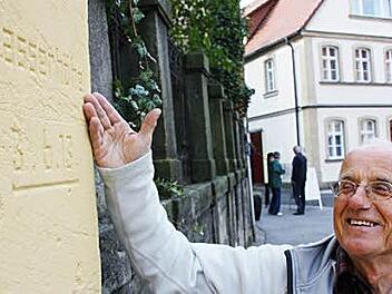 Rainer Haseloff zeigt die Markierung an der Spitalkirche, die auf das schlimme Hochwasser im Juni 1913 verweist. Foto: Eckehard Kieswetter