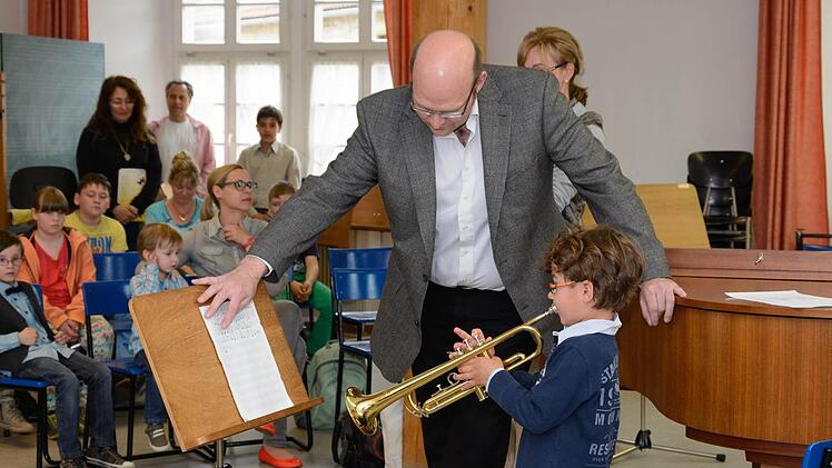 Der sechsjährige Tom unterhielt die Besucher mit einer Melodie auf der Trompete, mit dabei ist Thomas Reuß, der Leiter der Musikschule.