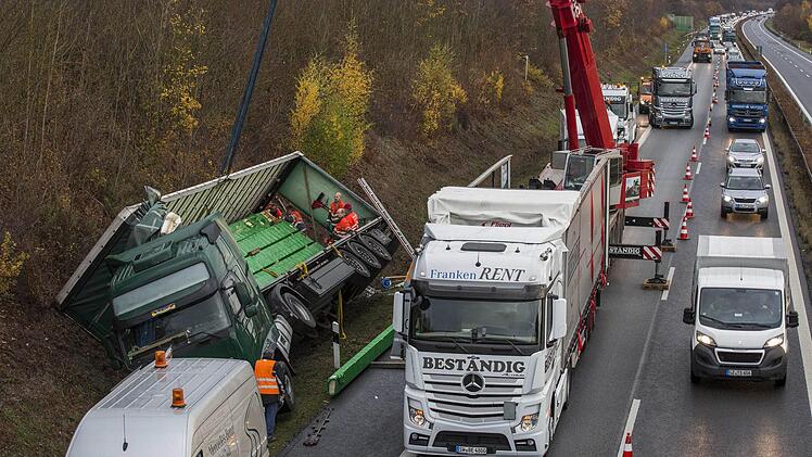An der Böschung landete der Holzlaster. Dort kippte er auf die Seite. Unser Bild entstand beim Umladen der Ladung.  Foto: René Ruprecht