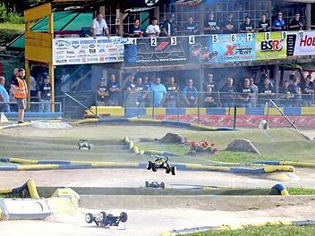 Tolle RC Buggy-Rennen gab es bei der Europameisterschaft in Sand. Im Hintergrund ist der Fahrerstand mit den Fahrern (oben) und den Mitgliedern der einzelnen Boxen-Crews (unten).  Foto: Ralf Naumann