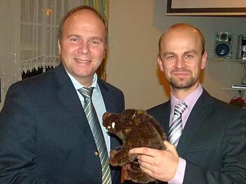 Der Vorsitzender der Bürgergemeinschaft, Tom Schultheiß (rechts), übergibt dem Hobby-Jäger Bernd Reisenweber ein Glücksschwein mit dem Wunsch auf "eine erfolgreiche Stimmenjagd". Foto: Lothar Weidner