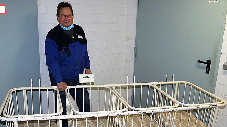 Hausmeister Stefan Rüpplein am alten, vierteiligen Kinderbett Will