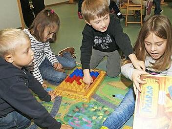 "Pharao heißt das Spiel", erklärt Lara, es geht um Pyramiden und einen Schatz. Benjamin, Sophie und Levin können zwar noch nicht lesen, aber das Spiel haben sie schon verstanden.  Foto: Sabine Weinbeer