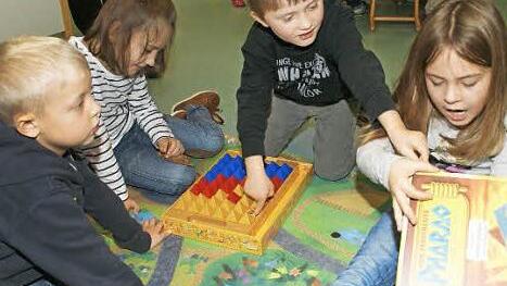 "Pharao heißt das Spiel", erklärt Lara, es geht um Pyramiden und einen Schatz. Benjamin, Sophie und Levin können zwar noch nicht lesen, aber das Spiel haben sie schon verstanden.  Foto: Sabine Weinbeer