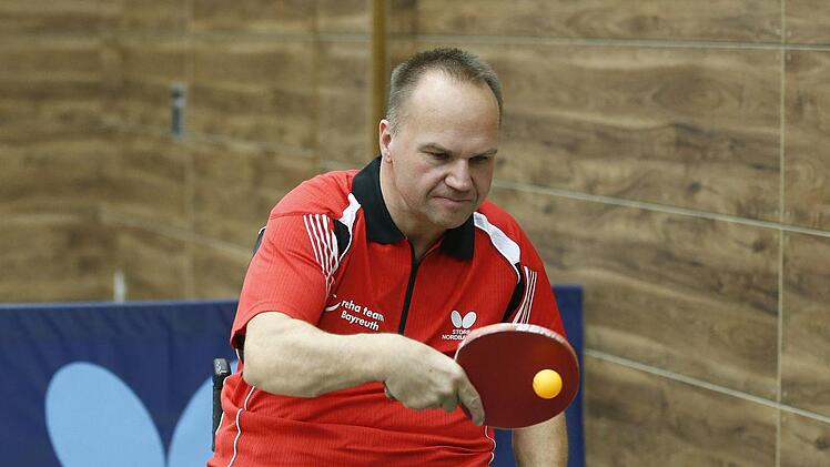 Dietmar Kober im Trikot des RSV Bayreuth mit einer Hand am Schläger und der anderen am Rollstuhlrad zum Manövrieren.  Foto: Peter Kolb