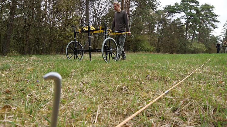 Nils Ostermeier schiebt den Handwagen mit den Magnetometer-Sonden über die abgesteckte Fläche. Foto: Arkadius Guzy