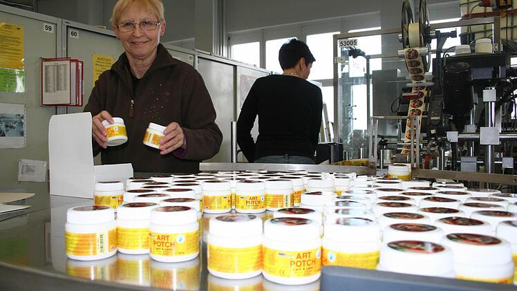 Marion Greger beim Verpacken von Dosen mit Serviettenklebern