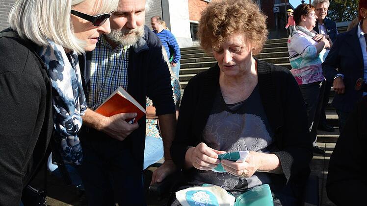 Ehepaar Sikora schaut Anita Lenaerts bei der Nadelstickerei zu.
