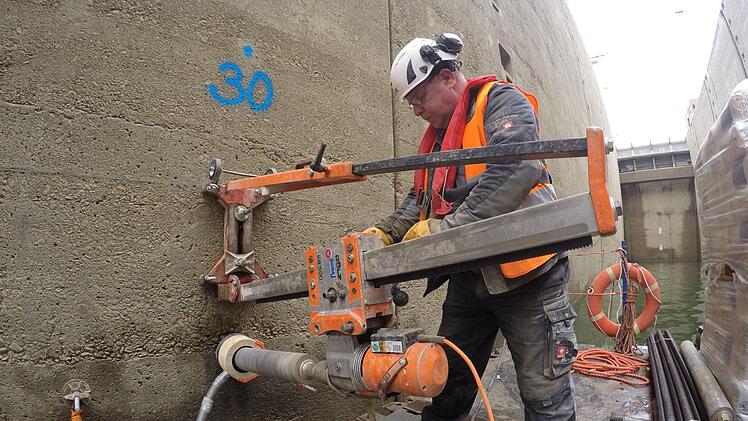 Die Arbeiter in der Schleuse Erlangen bohren in die Schleusenwände, um stärkere Bewehrungen einzufügen.