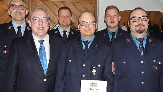 Das Staatliche Ehrenzeichen in Silber bekam Markus Gräf (mit Urkunde). Mit im Bild (von links) Kreisbrandinspektor Siegfried Zillig, Bürgermeister Harald Hübner, Kreisbrandmeister Thomas Hoffmann, Vorsitzender Jonas Paulini und Kommandant Alexander Meixner  Foto: Horst Wunner
