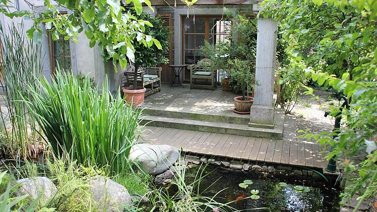 Blick vom Gartenteich auf die Veranda am Pflanzenhaus. Foto: Michael Schulbert