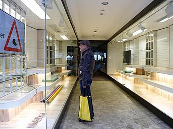 Hausbesitzer Gerd Limberg steht in der leeren Schaufenster-Passage. Auf einem Monitor wird die Wiedereröffnung angekündigt. Foto: Matthias Hoch
