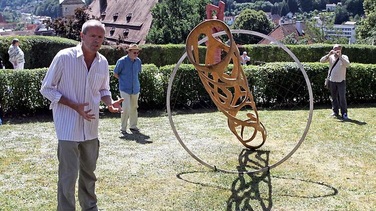 Aus einem 800 Kilogramm schweren Baumstamm aus Eiche fertige Detlef Rohrbach eine schwebende rund 40 Kilogramm schwere Skulptur. Sie symbolisiert einen umgefallenen Baum, der sich wieder aufrichtet. Um das "Spannungsfeld" zu halten setzt der in Berlin geboren Künstler einen Edelstahlring und dünne Seile ein. Fotos: Michael Wunder