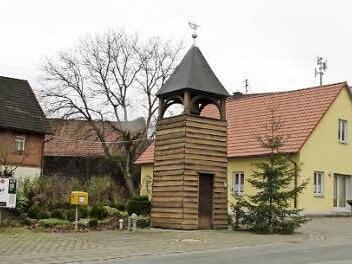 Die Ortsmitte prägen ein Zigarettenautomat, ein Briefkasten, der Glockenturm, das Gemeinschaftshaus und ein Bus-Wartehäuschen.