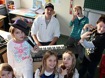 Ausgelassen und doch hochkonzentriert: In der kleinen Rap-Werkstatt der Volksschule Schwarzacher Becken sind Akim Aker und die kleinen Künstler voll bei der Sache.  Fotos: Peter Pfannes