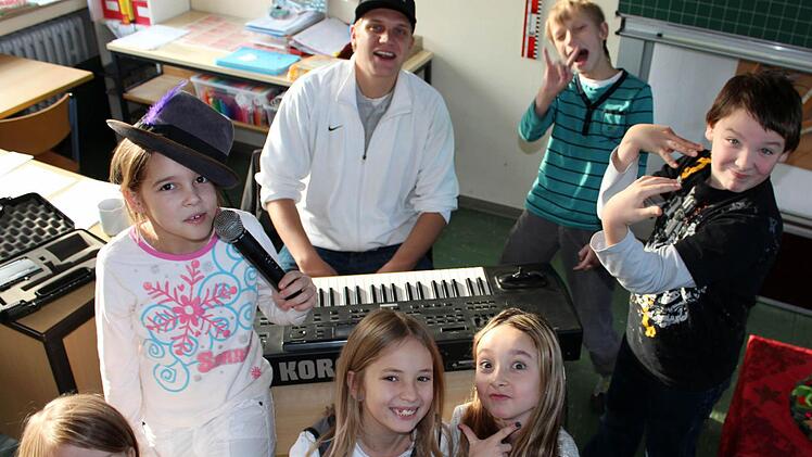 Ausgelassen und doch hochkonzentriert: In der kleinen Rap-Werkstatt der Volksschule Schwarzacher Becken sind Akim Aker und die kleinen Künstler voll bei der Sache.  Fotos: Peter Pfannes