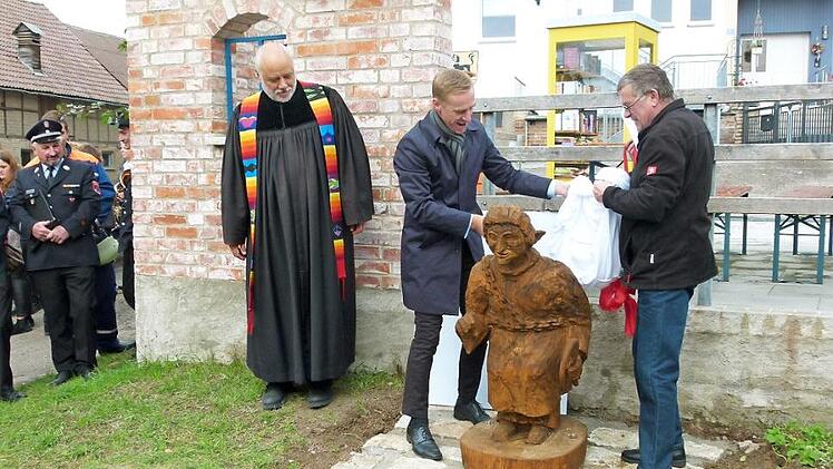 Pfarrer Eberhard Wunder, Bürgermeister Bernd Höfer (Mitte) und Hartmut Sollmann enthüllen die Statue der Hullewaatsch. Foto: Lothar Weidner