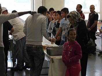Essensausgabe in der Notunterkunft: Die Flüchtlinge stehen in einer langen Reihe an, es gibt ein Reisgericht zu Mittag. Foto: Katharina Zimmermann