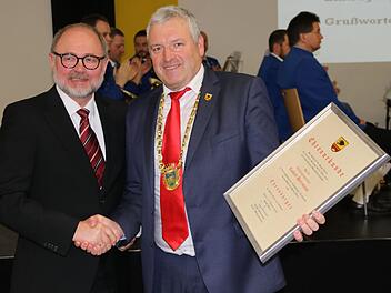 Bürgermeister Jürgen Hennemann (rechts) überreicht an  Robert Herrmann die Ehrenurkunde zur Ernennung als Ehrenbürger der Stadt Ebern. Helmut Will