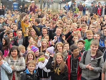 Mittendrin im Trubel stecken Radio-Moderator Florian Weiss (mit gelbem Mikrofon in der rechten Hand) und der Schulchef Hartmut Weis. Sie jubeln mit den Kindern und Jugendlichen am Freitagmittag über die tolle Nachricht. Ebern hat beim bayernweiten Voting gewonnen. Foto: Doris Will