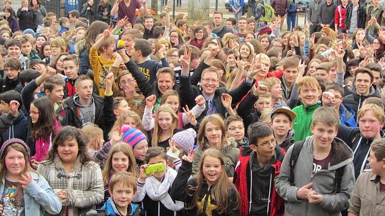 Mittendrin im Trubel stecken Radio-Moderator Florian Weiss (mit gelbem Mikrofon in der rechten Hand) und der Schulchef Hartmut Weis. Sie jubeln mit den Kindern und Jugendlichen am Freitagmittag über die tolle Nachricht. Ebern hat beim bayernweiten Voting gewonnen. Foto: Doris Will