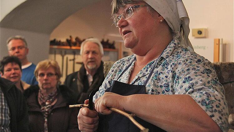 "Winzerin" Christiane Schmid erklärt, wie mühsam früher die Arbeit auf dem Weinberg war. Foto: Gerd Schaar