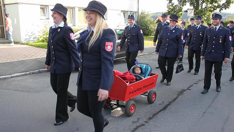 Die Patenwehr aus Mainroth fuhr den elf Monate alten Lukas Stenglein in seinem "Feuerwehrmobil" durch den Ort spazieren. Foto: Stephan Stöckel
