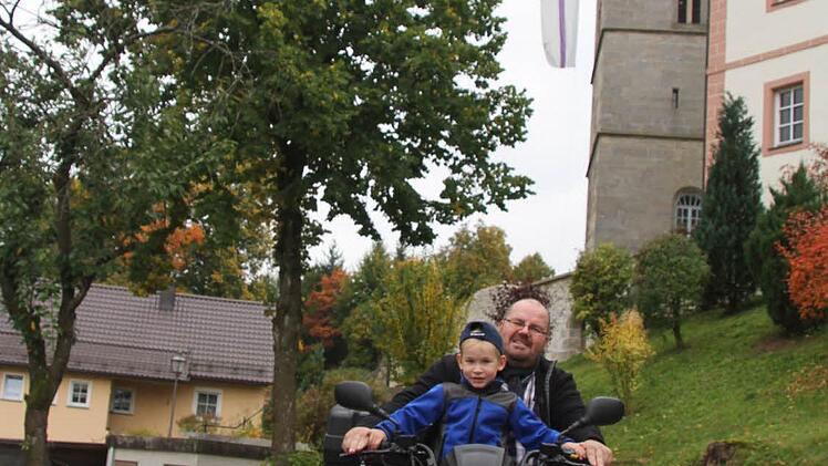 Pfarrer Christian Schmidt - mit seinem Sohn Felix (5) liebt ausgefallene Fahrzeuge wie sein Quad. Foto: Sonja Adam