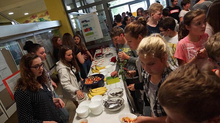 Schüler drängeln sich um die Tische mit Obstsalat und vegetarischem Chili aus fair gehandelten Zutaten. Foto: Arkadius Guzy