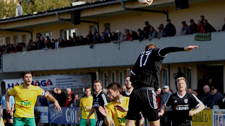 Der Sander Dominic Leim (Nr. 17) hier den Ball mit dem Kopf vor dem Bamberger Daniel Schäffler (Vierter von rechts) ab. Links der Bamberger Kapitän Christopher Kettler