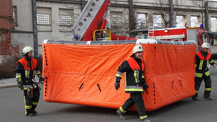 Die Feuerwehr bringt das Rettungskissen weg.