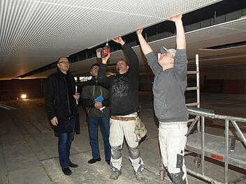 Viel Arbeit macht die neue Akustikdecke der Hegler-Halle. Sven Tischer und Sven Berninger (rechts) vom Farbenhaus Bruckmüller (Münnerstadt) montieren die Elemente. Architekt Johannes Messerschmitt (links) und 2. Bürgermeister Gerhard Fischer schauen zu.  Foto: Stefan Geiger