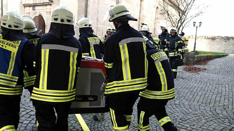 Die Löschfahrzeuge passen nicht durch das Tor zum Innenhof, weshalb die Feuerwehrleute alle notwendigen Gerätschaften auf den letzten Metern per Hand transportieren müssen.       Foto: Richard Sänger