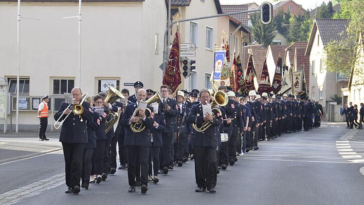In einer langen Reihe wehender Fahnen paradierten die Feuerwehren der Stadt Bad Kissingen zur St. Laurentius Kirche und zurück zum Feuerwehrhaus. Foto: Peter Klopf