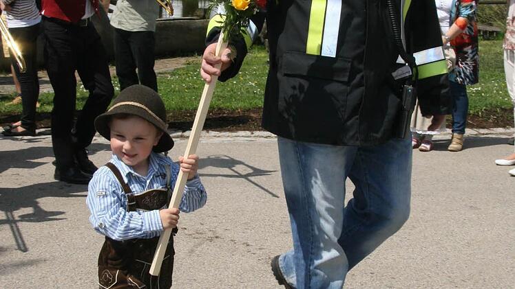 Früh übt sich, wer ein Meister werden will: Der Schildträger war so jung, dass er noch ein bisschen Schützenhilfe brauchte - dafür kann er locker beim 100-Jährigen dabei sein.