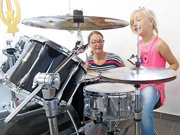 Astrid Krappmann gab Tipps zum Instrument: Die siebenjährige Lucy versuchte sich am Schlagzeug. Fotos: Monika Schütz