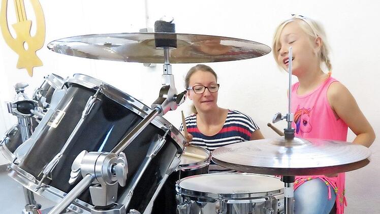 Astrid Krappmann gab Tipps zum Instrument: Die siebenjährige Lucy versuchte sich am Schlagzeug. Fotos: Monika Schütz
