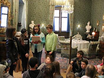 Im Blauen Salon tragen Simon (von rechts), Sandra und Joanna den Klassenkameraden ihre Forschungsergebnisse zu Luise von Luxburg vor, Die Museumspädagogin Katja Kraus (links) hat sie bei ihren Recherchen begleitet. Zum Museumsfest werden die Kinder ihr Wissen präsentieren. Foto: Kathrin Kupka-Hahn