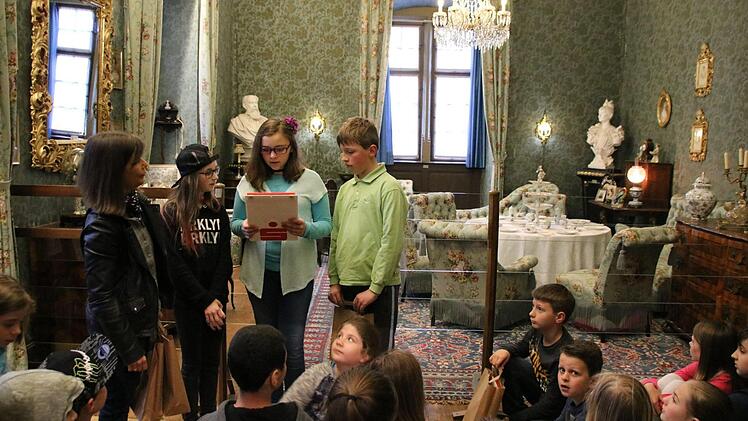 Im Blauen Salon tragen Simon (von rechts), Sandra und Joanna den Klassenkameraden ihre Forschungsergebnisse zu Luise von Luxburg vor, Die Museumspädagogin Katja Kraus (links) hat sie bei ihren Recherchen begleitet. Zum Museumsfest werden die Kinder ihr Wissen präsentieren. Foto: Kathrin Kupka-Hahn