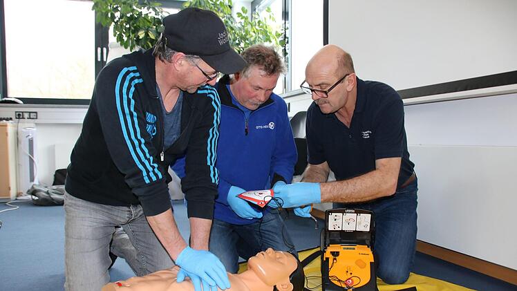 Unter Anleitung von Rettungsassistent Uve Bartz (rechts) üben Frank Keidel und Ulf Wagner an einer Puppe die Herz-Lungen-Wiederbelebung: 30 Mal drücken, dann zwei Atemstöße. Foto: Ralf Ruppert