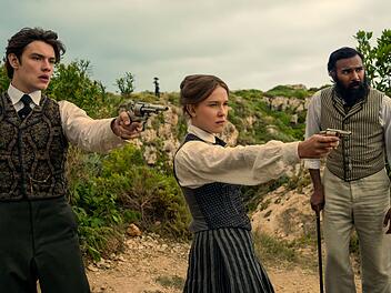 Tewkesbury (Louis Partridge, links), Enola Holmes (Millie Bobby Brown) und Dr. Watson (Himesh Patel) lassen nichts unversucht, um Sherlok zu befreien.